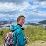 Person mit Rucksack vor Landschaft und Meer