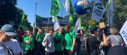 Menschen demonstrieren mit Bannern und Flaggen für den Klimaschutz.