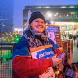 Lächelnde Person mit Schild bei Abendveranstaltung