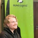 Junger Mann vor einer BUNDjugend Fahne