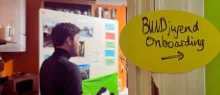 Person beim Onboarding-Event mit Wandnotizen