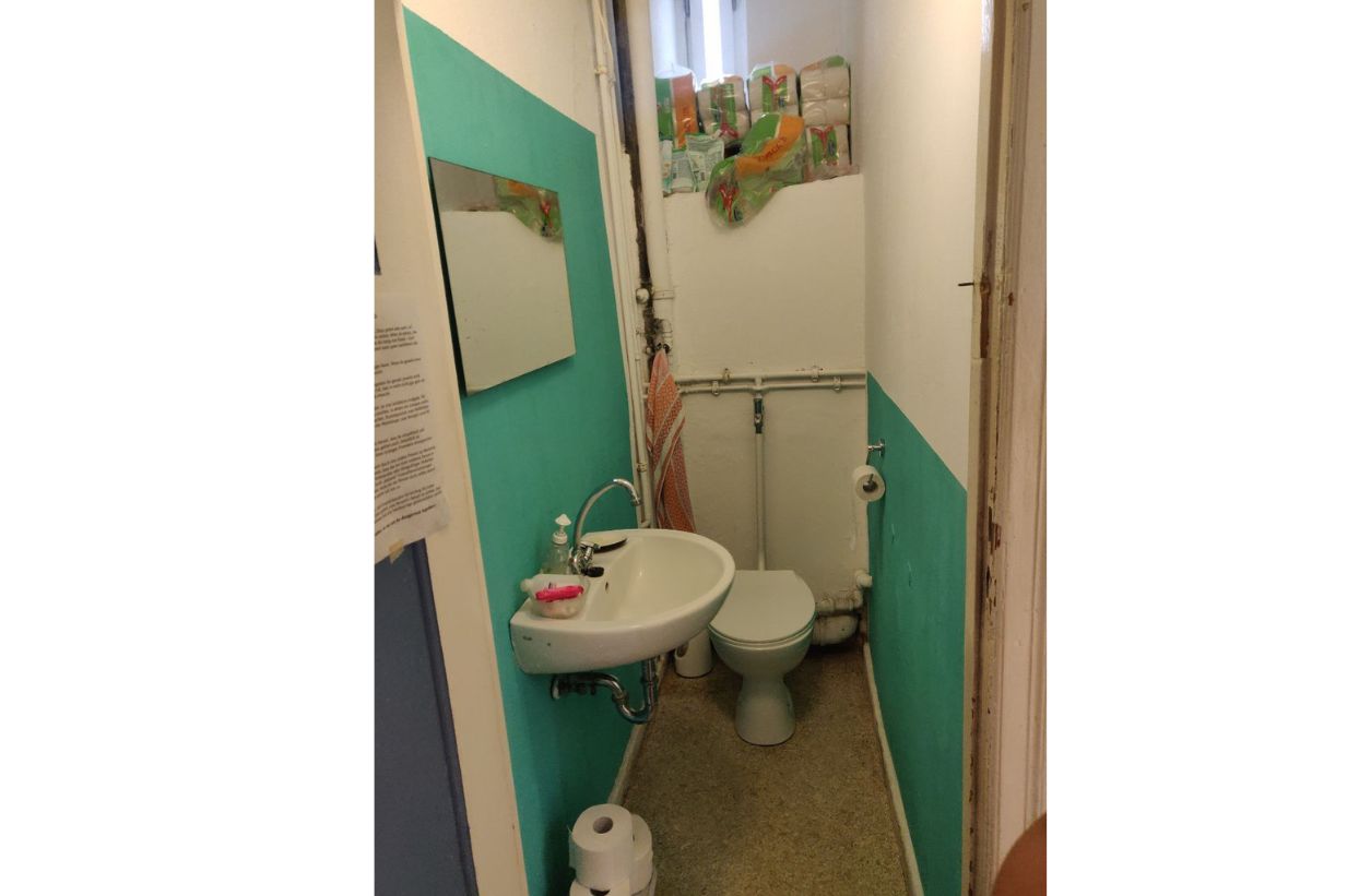 Kleines Badezimmer mit Waschbecken und Toilette.