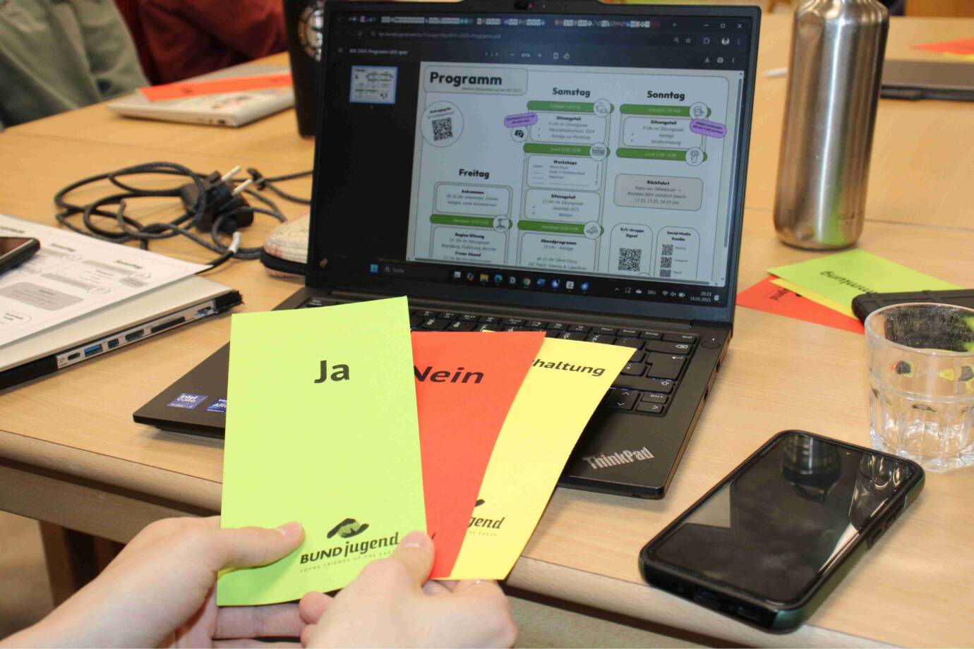 Abstimmungskarten vor Laptop mit Programmübersicht