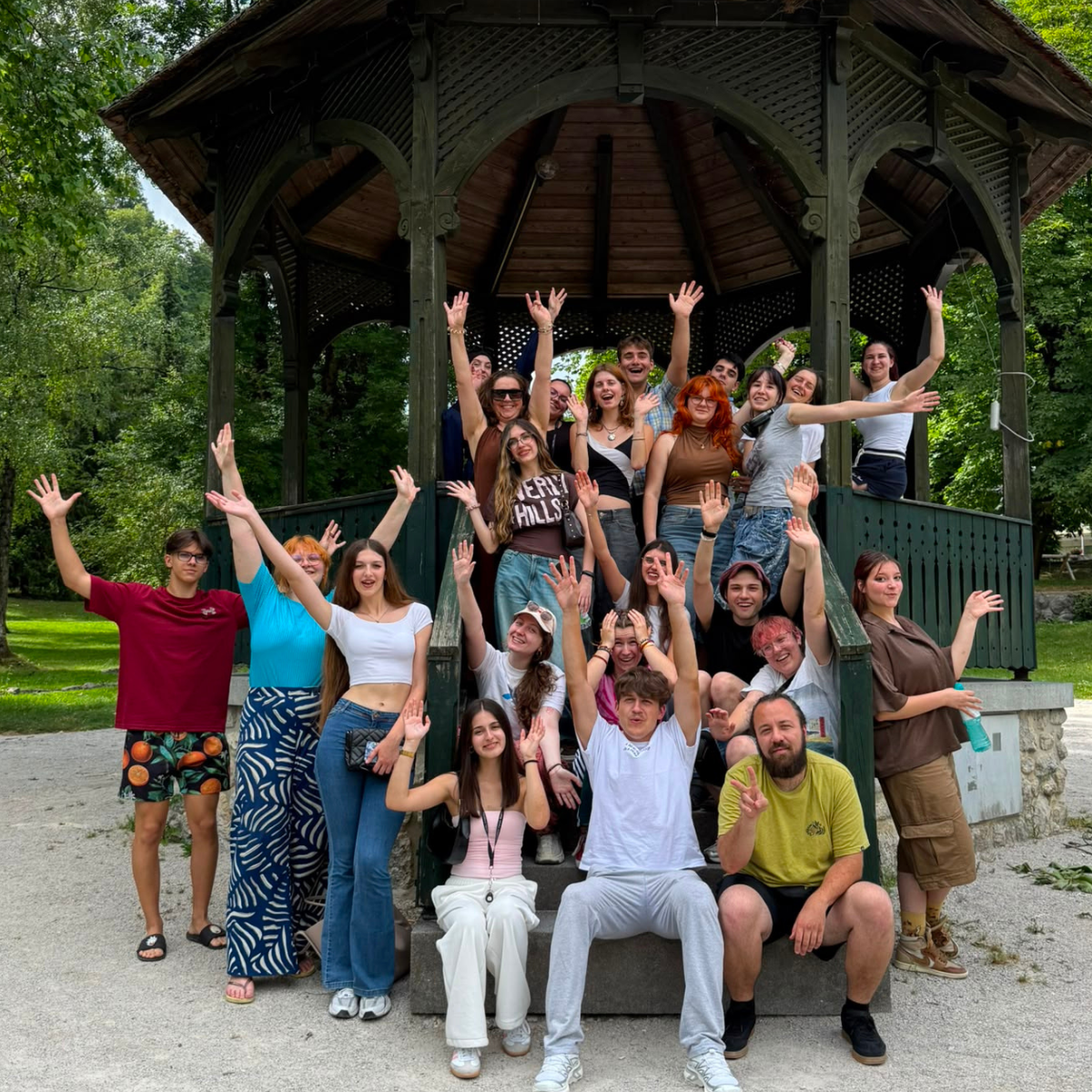 Fröhliche Gruppe junger Menschen unter Pavillon im Park