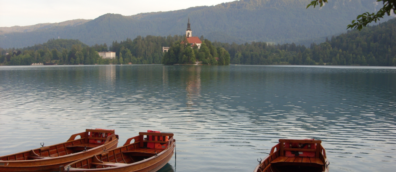 Holzboote am Bleder See mit Insel im Hintergrund